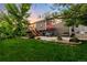 Spacious backyard and patio area with a table and chairs under a red umbrella at 1758 Parkdale N Cir, Erie, CO 80516