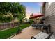 Well manicured backyard and patio with a table and chairs under a red umbrella at 1758 Parkdale N Cir, Erie, CO 80516