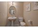 Half bath features a pedestal sink and toilet, complemented by tasteful wall decor at 1758 Parkdale N Cir, Erie, CO 80516