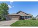 Charming single-story home with a brick facade, well-manicured lawn, and a three-car garage at 1758 Parkdale N Cir, Erie, CO 80516