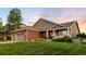 Charming two-story home with a well-manicured lawn, brick accents, a covered porch and attached two car garage at 1758 Parkdale N Cir, Erie, CO 80516