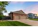 Spacious two car garage with brick accents and a well-maintained lawn at 1758 Parkdale N Cir, Erie, CO 80516