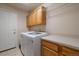 Functional laundry room with modern machines, cabinetry, and a countertop for folding at 1758 Parkdale N Cir, Erie, CO 80516