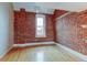 Bedroom with exposed brick wall, hardwood floors, and a window at 3233 Osage St # 2A, Denver, CO 80211