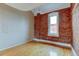 Simple bedroom with exposed brick wall and hardwood floors at 3233 Osage St # 2A, Denver, CO 80211