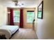 Bright bedroom featuring large windows with red curtains and a plush carpet at 15292 E Hialeah Pl, Aurora, CO 80015