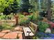 A serene garden with lush greenery and a rustic wooden bench, perfect for relaxation at 15292 E Hialeah Pl, Aurora, CO 80015