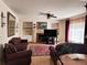 Comfortable living room with a fireplace, built-in shelving, and two leather couches at 15292 E Hialeah Pl, Aurora, CO 80015