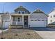 Charming gray two-story home featuring a covered porch, white trim, and a two-car garage at 968 Congress Pl, Elizabeth, CO 80107