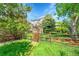 A wooden fence with a gate encloses a backyard showcasing lush greenery and mature trees around the property at 20530 Parker Vista Cir, Parker, CO 80138