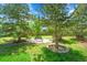 A serene backyard retreat with a charming bench nestled between mature trees and decorative rock features at 20530 Parker Vista Cir, Parker, CO 80138