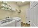 Bright laundry room with modern washer and dryer units and storage shelves at 20530 Parker Vista Cir, Parker, CO 80138