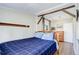 Cozy bedroom featuring wood floors, exposed beam, and bright natural light from an exterior window at 6743 Wild Rose Ln, Evergreen, CO 80439
