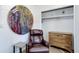 Bedroom sitting area featuring a comfortable armchair, dresser, and artistic decor for a relaxed space at 6743 Wild Rose Ln, Evergreen, CO 80439