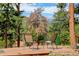 Outdoor deck featuring two chairs offering beautiful views of a lush green forest and majestic mountains at 6743 Wild Rose Ln, Evergreen, CO 80439