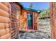 Cozy cabin entrance with a red-framed glass door and a charming welcome sign at 6743 Wild Rose Ln, Evergreen, CO 80439