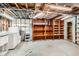 Unfinished basement area with laundry, shelves, and access to utilities at 798 Alkire St, Lakewood, CO 80401