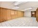Spacious basement featuring tile flooring and knotty pine wall paneling and bi-fold doors at 798 Alkire St, Lakewood, CO 80401