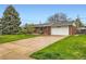 Brick home featuring a long driveway leading to the attached garage and manicured front lawn at 798 Alkire St, Lakewood, CO 80401