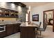 Stylish bar area featuring stone accent wall, cabinetry, marble counters, and seating for two at 41 Stillson Placer Ter, Breckenridge, CO 80424