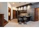 Stylish bar area with stone accent wall, bar seating, cabinets, and an open doorway to the wine room at 41 Stillson Placer Ter, Breckenridge, CO 80424