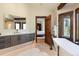Modern bathroom features a soaking tub, gray vanity with storage, and an open doorway to the bedroom at 41 Stillson Placer Ter, Breckenridge, CO 80424
