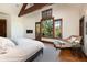 Spacious bedroom features hardwood floors, a fireplace, beam ceilings, and a lounge chair near the window at 41 Stillson Placer Ter, Breckenridge, CO 80424