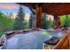Outdoor hot tub with stone columns and views of the mountains and trees at 41 Stillson Placer Ter, Breckenridge, CO 80424