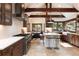 Open kitchen features an island with stool seating, stone floors, stainless appliances, and beautiful lighting at 41 Stillson Placer Ter, Breckenridge, CO 80424