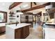 Open-concept kitchen featuring an island, stainless appliances, breakfast bar, and wood beams at 41 Stillson Placer Ter, Breckenridge, CO 80424
