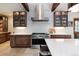 Kitchen with stainless steel range hood, marble countertops, stone floors, and custom cabinetry at 41 Stillson Placer Ter, Breckenridge, CO 80424