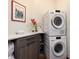 Bright laundry room with modern stacked washer and dryer, gray cabinets, and marble countertops at 41 Stillson Placer Ter, Breckenridge, CO 80424