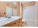 Bathroom featuring a vanity, mirror, and a shower-tub combo with white tile surround at 14211 E 1St Dr # 308, Aurora, CO 80011