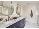Bathroom featuring double sinks, marble counters, and a glass enclosed shower at 900 Locust St, Denver, CO 80220