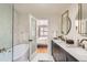 Bathroom featuring a tub and double sinks with view into bedroom at 900 Locust St, Denver, CO 80220