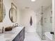Bathroom featuring double sinks, marble counters, and a glass enclosed shower at 900 Locust St, Denver, CO 80220