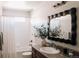 Bright bathroom featuring a tub and shower combination with white tile and a modern vanity with a decorative mirror at 2741 Sunset Way, Erie, CO 80516