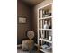 Bedroom corner with a wicker chair, shelving unit with decorative objects, and soft, muted colors at 2741 Sunset Way, Erie, CO 80516