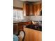 Close up of a kitchen with wood cabinets, stainless steel appliances, granite countertops, and a window at 2741 Sunset Way, Erie, CO 80516