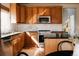 Sun-lit kitchen featuring stainless steel appliances, granite countertops, wood cabinets, and modern fixtures at 2741 Sunset Way, Erie, CO 80516