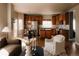 Open-concept kitchen and dining area with wooden cabinetry and stainless steel appliances at 2741 Sunset Way, Erie, CO 80516