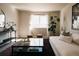 Bright living room with large windows, a white sofa, and a decorative monstera plant at 2741 Sunset Way, Erie, CO 80516