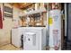 Functional laundry area with washer, dryer, water heater and wall shelving for storage at 2060 S Lowell Blvd, Denver, CO 80219