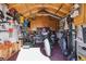 Organized shed features pegboard walls, wooden cabinets, lawn mower, and motorcycle at 2060 S Lowell Blvd, Denver, CO 80219