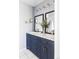 Stylish bathroom with dual sinks, blue vanity, framed mirrors, and modern fixtures at 4215 W Byron Pl, Denver, CO 80212