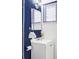 Cozy bathroom with blue accent wall, single vanity and framed mirror at 4215 W Byron Pl, Denver, CO 80212