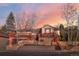 Charming two-story home with red brick accents and a cozy front porch against a vibrant sunset sky at 4215 W Byron Pl, Denver, CO 80212