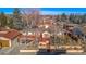 Charming home exterior with vibrant red trim, multiple decks, mature trees, and well-manicured landscaping at 4215 W Byron Pl, Denver, CO 80212
