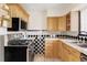 Traditional kitchen features tile countertops, stainless steel appliances, and light wood cabinetry at 4215 W Byron Pl, Denver, CO 80212