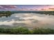 Scenic lake reflecting a pink sunset sky, mountains in the distance, and lush greenery at 4215 W Byron Pl, Denver, CO 80212